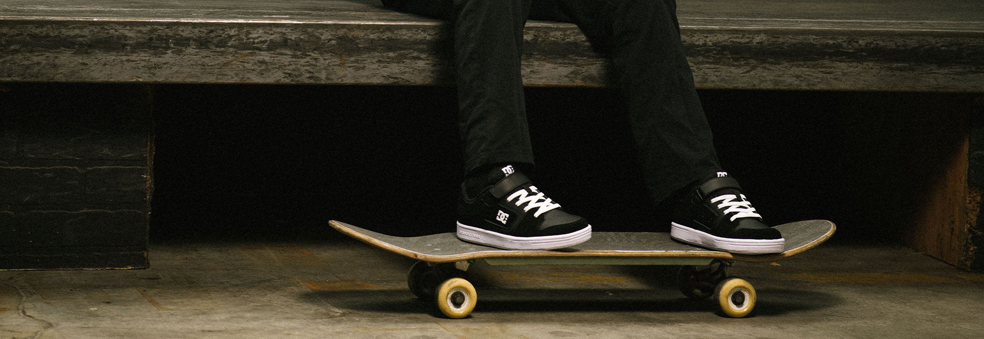 A kid wearing DC Shoes riding a skateboard