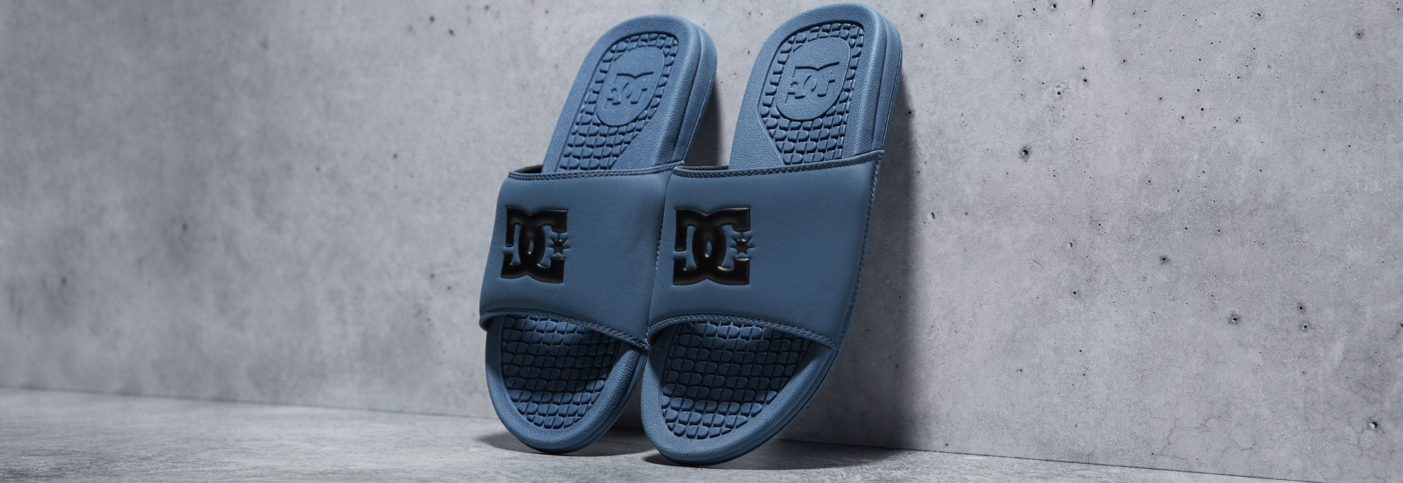 A pair of teal slides being propped up against a wall