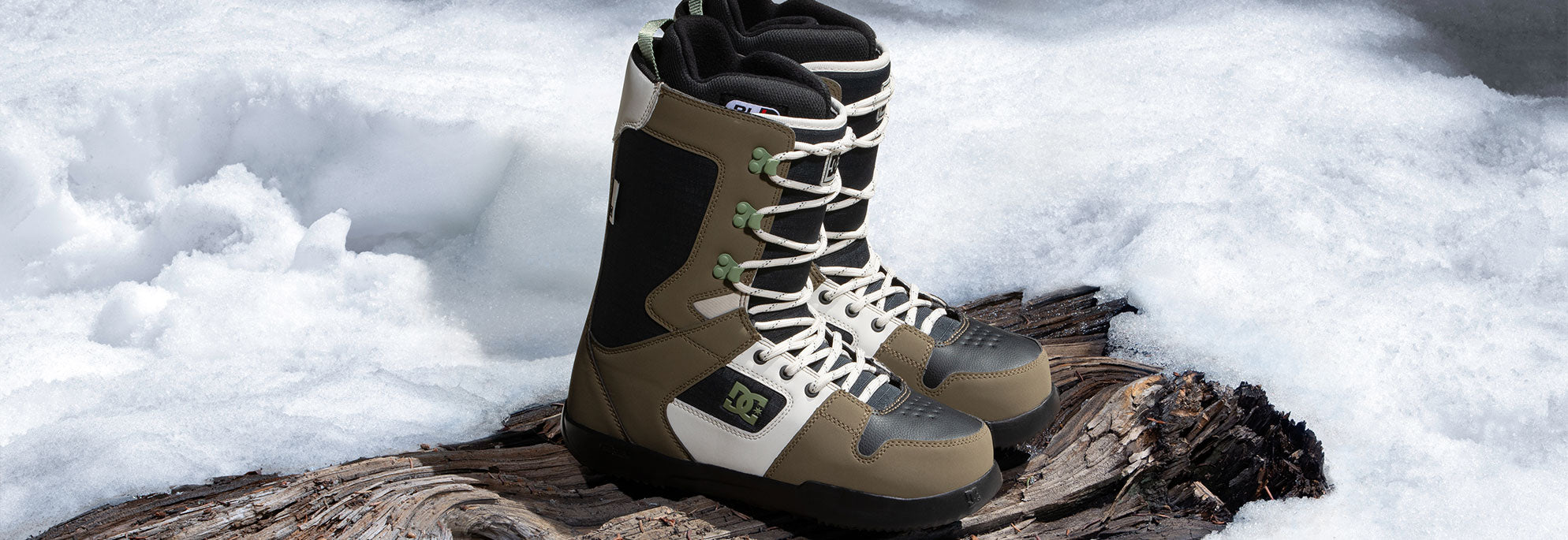 A pair of snowboard boots with a wintery background
