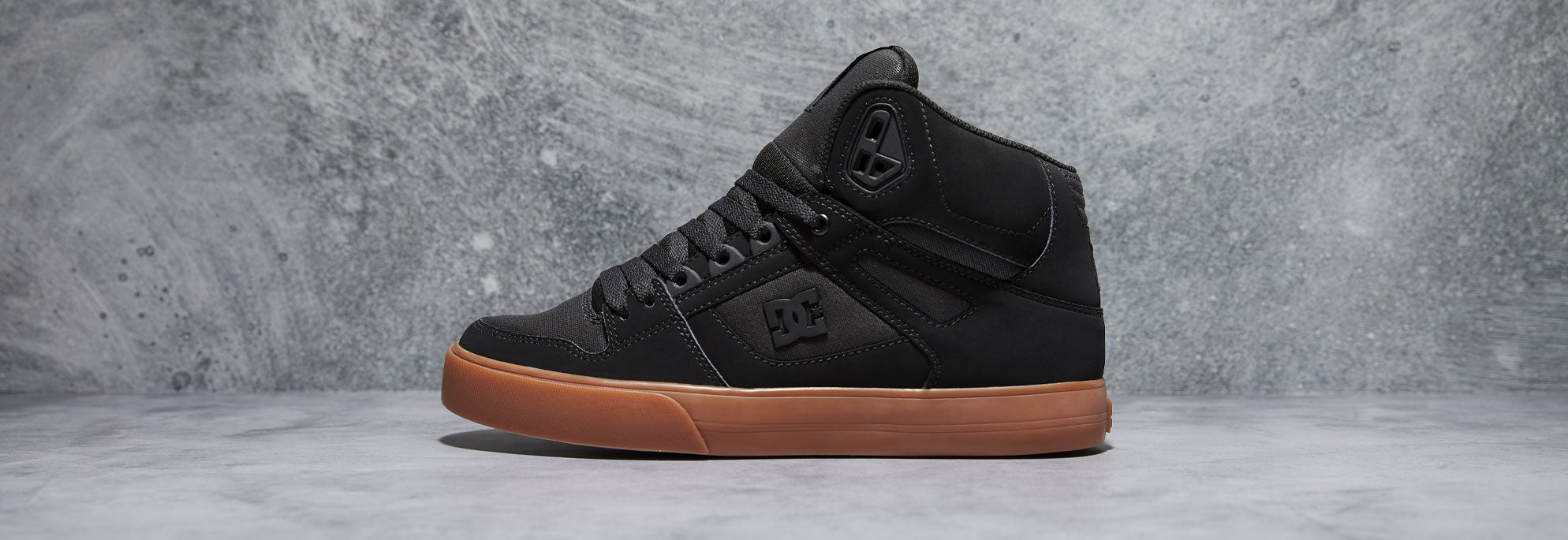 A black pair of shoes with a brown sole