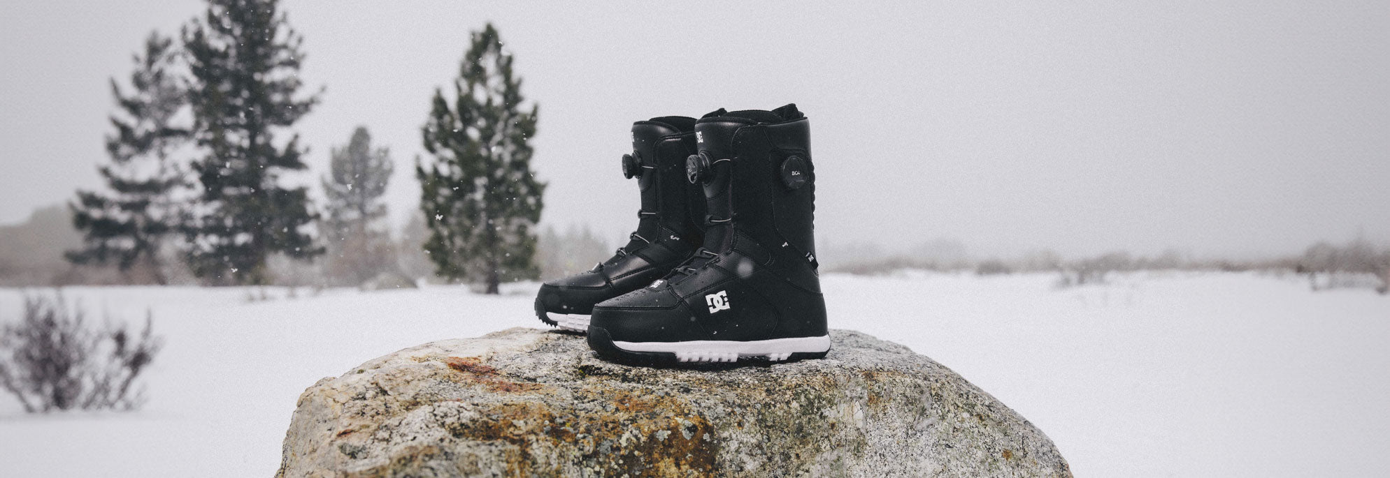 Snowboard Boots with a snowy background on a rock
