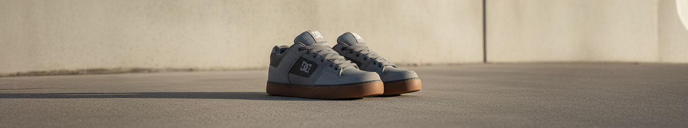 Gray sneakers on concrete illuminated by a warm sunset glow