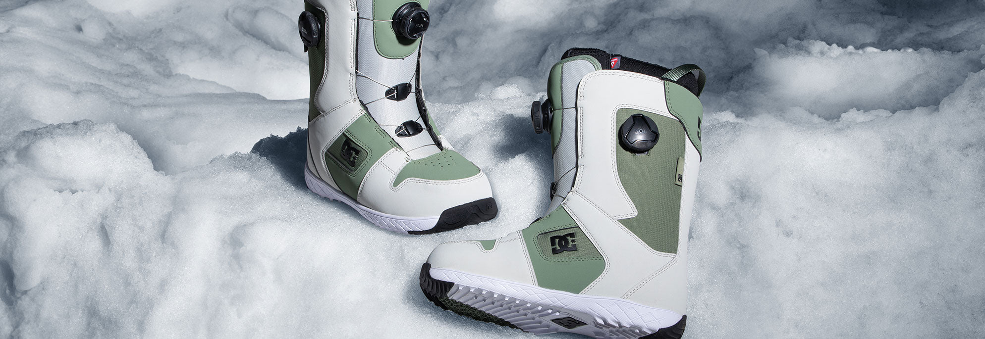 A pair of snowboard boots with snow in the background