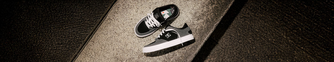 Pair of black and white sneakers on concrete