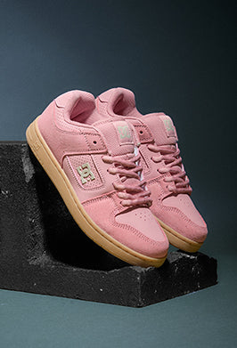 Pink sneakers with visible brand logo on a dark background