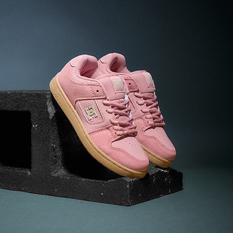 Pink sneakers with a black block on a dark background
