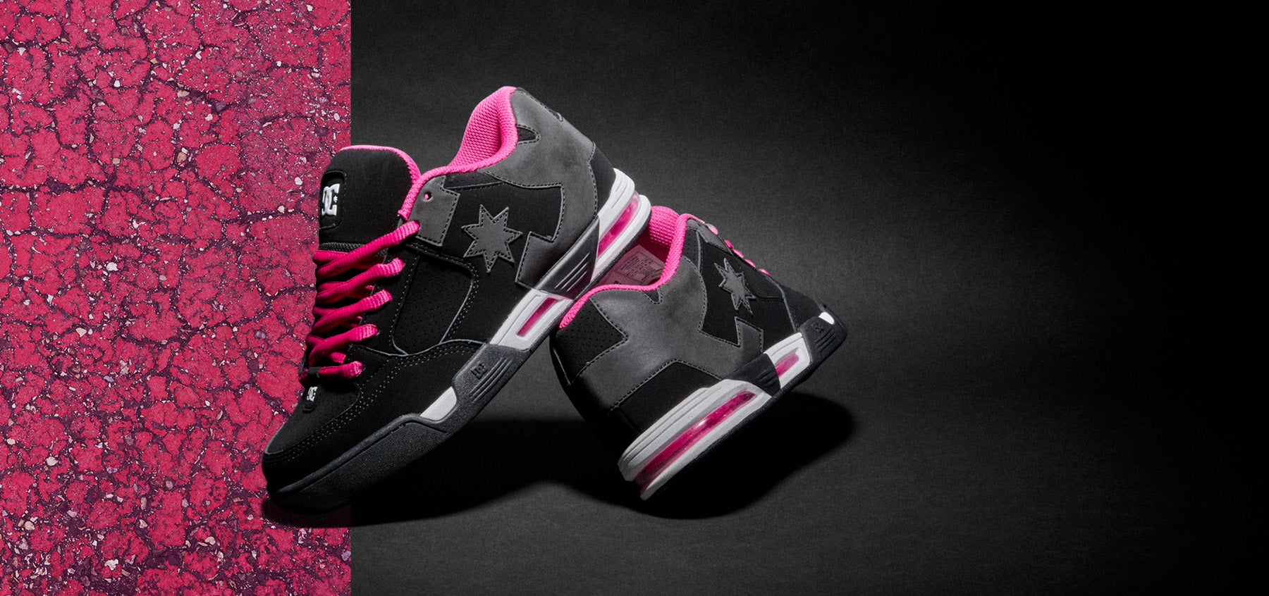 Black and pink sneakers on a dark background with a pink textured border.