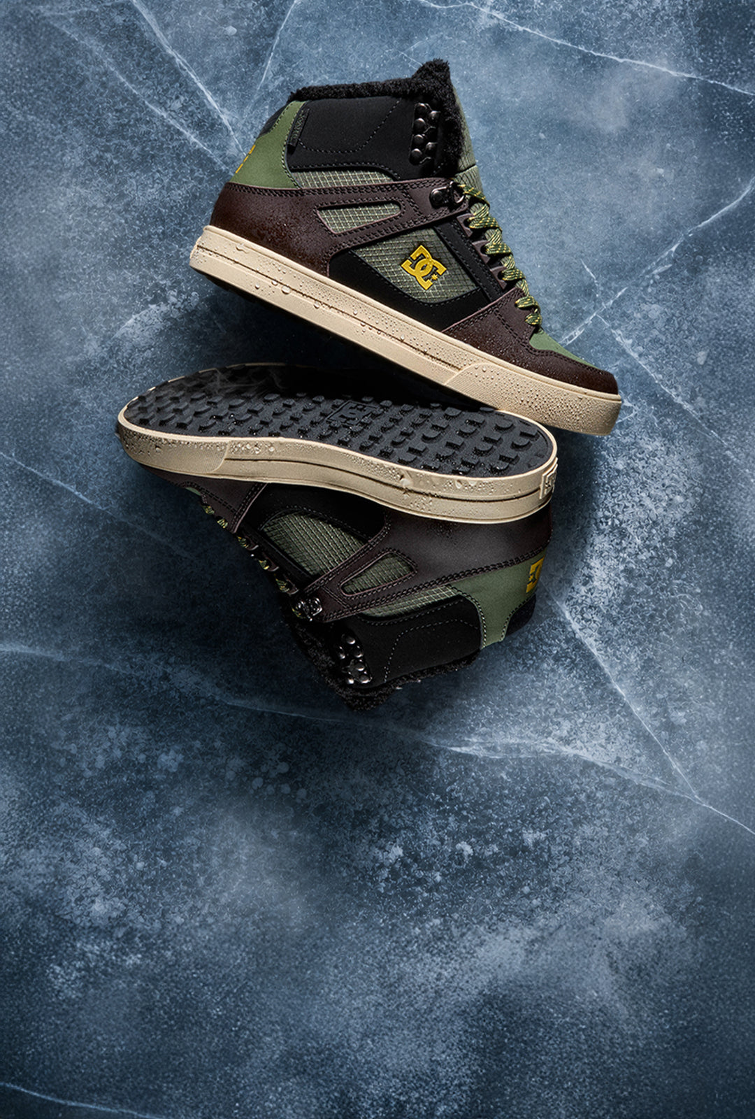 Two black, brown, and olive DC winterized sneakers arranged on a textured icy blue surface.