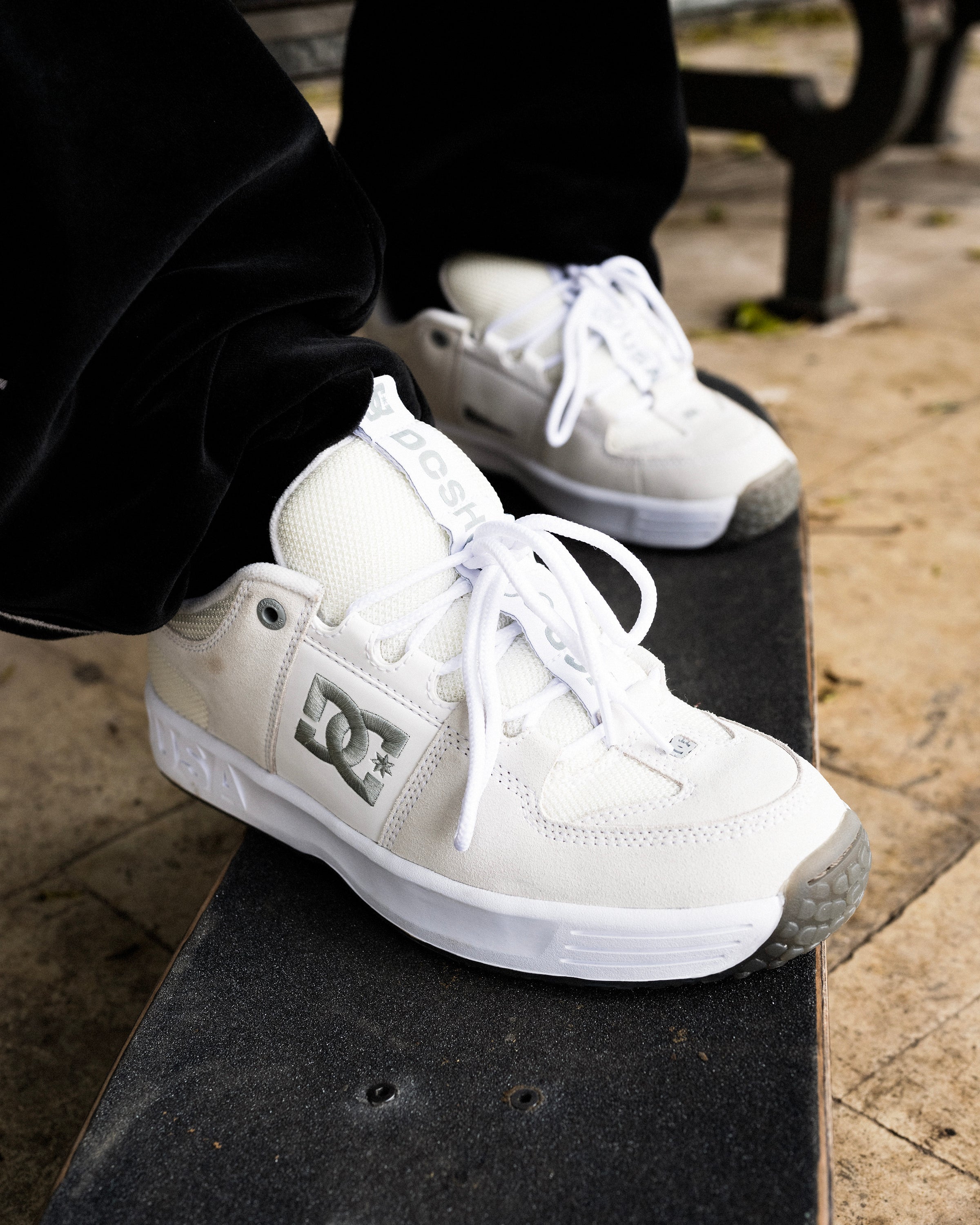 Heritage shoes in white and grey worn by someone with their feet on a skateboard