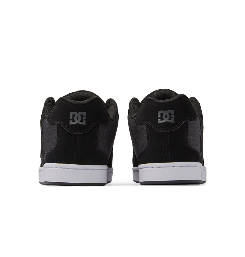 Men's Net Shoes by DC Shoes in black, shown from the back with gray DC logos on each heel and white soles. Made from durable fabrics for long-lasting wear.