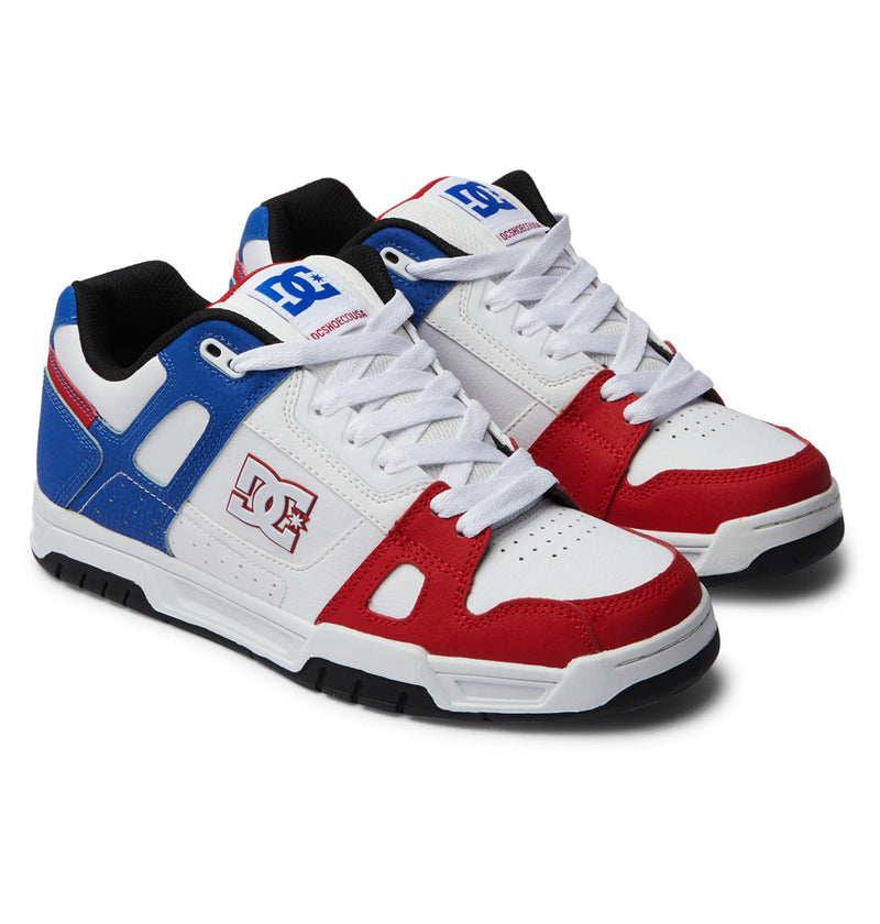 The DC Shoes Men's Stag Shoes feature red, white, and blue panels, white laces, black soles, oversized puff details, a durable cupsole, and the DC logo on the tongue and side.