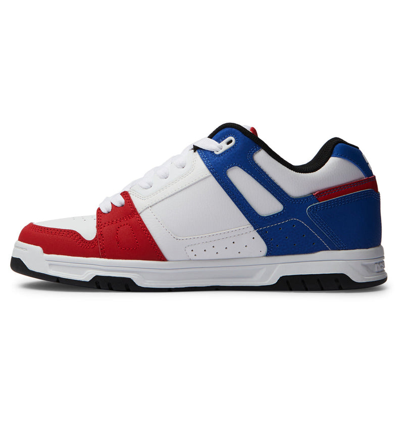 The DC Shoes Men's Stag Shoes are low-top sneakers with a white base, red toe and heel accents, blue midfoot and collar panels, white laces, a black-lined sole, and a durable cupsole for lasting wear.