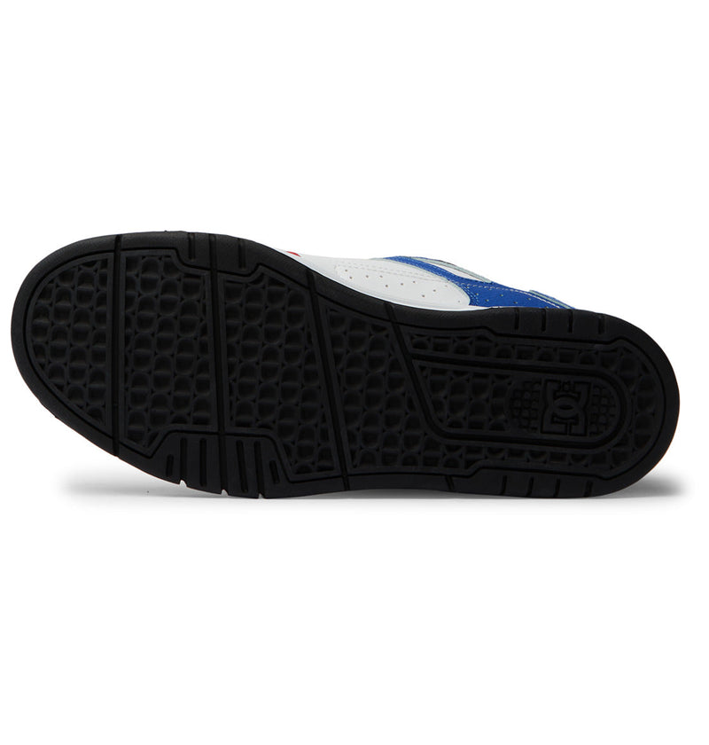 The image displays the black rubber cupsole with a textured pattern of the Men's Stag Shoes by DC Shoes. The blue and white upper is partly visible on the sides and heel.
