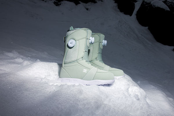 Womens snow board boots seen in a pile of snow