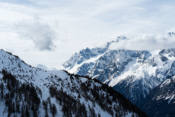 Snowy mountain range with clouds in the sky
