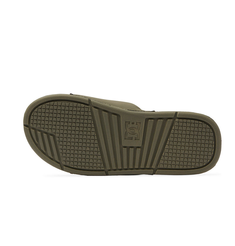 Bottom view of the Men's Bolsa Slides in olive green by DC Shoes, showing a textured rubber sole with grid and stripe patterns and a bold raised DC Shoes logo—ideal comfort after skating.