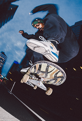 Person skateboarding on a reflective surface with a cityscape background