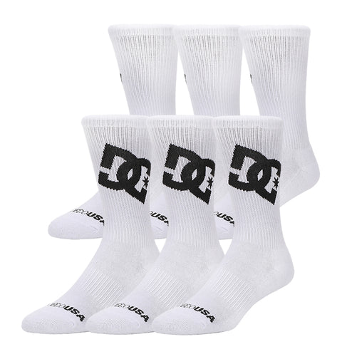 The DC Shoes Graffik Logo Crew Socks 3-Pack includes three pairs of white crew socks featuring the large black DC Shoes logo on the sides and "DC USA" in black near the toes, shown arranged against a white background.