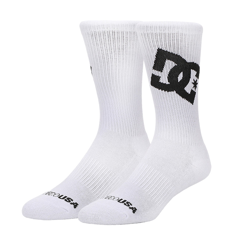 The Graffik Logo Crew Socks 3-Pack by DC Shoes features white crew socks with black DC Shoes logos on the sides and "DC SHOES USA" text on the toes.