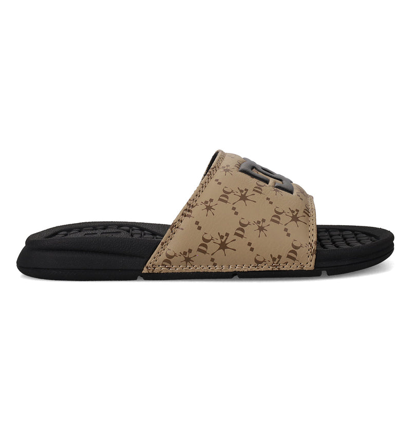 The DC Shoes Kids' Bolsa Slides feature a brown and black design, a textured footbed, and a wide strap with subtle dark brown symbols—perfect comfy slides for any occasion.