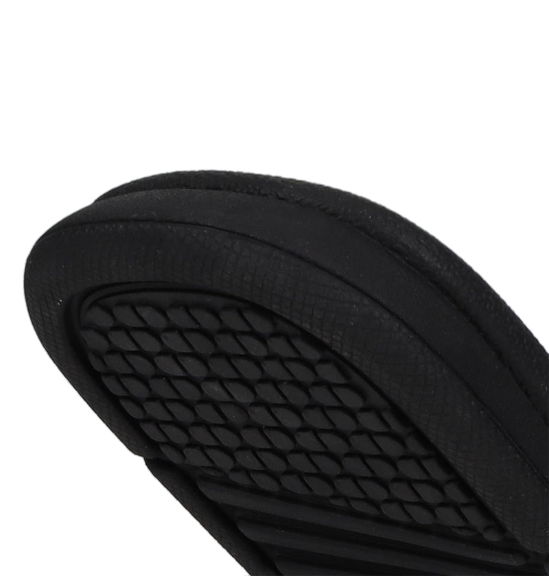 Close-up of the black rubber sole of DC Shoes Kids' Bolsa Slides, featuring textured diamond-shaped tread patterns for grip—ideal for comfortable kids slide sandals.