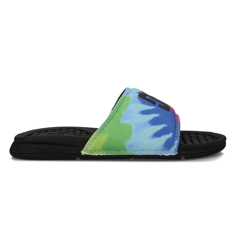 A single Kids' Bolsa Slide by DC Shoes, featuring a black sole and a vibrant tie-dye strap in blue, green, and yellow, shown in side profile on a white background—ideal comfy slides for kids.