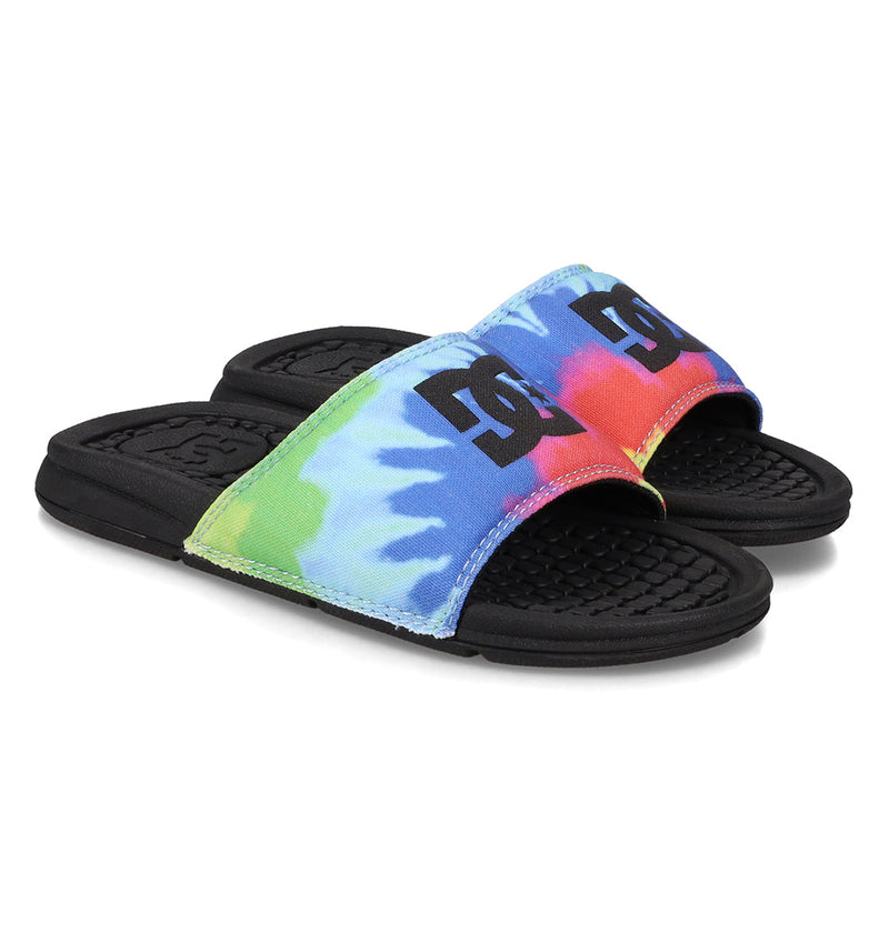 The Kids' Bolsa Slides by DC Shoes feature vibrant tie-dye straps with the DC logo, a textured black sole, and comfy design—perfect for kids who want both style and comfort.