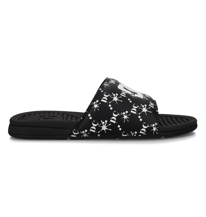 The Men's Bolsa Slides by DC Shoes feature a black design with a patterned strap of white abstract designs and a textured sole, ideal for post-skate comfort. Shown here in a sleek side profile view.