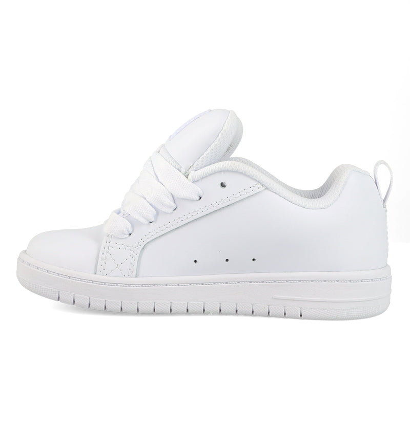 The Kids' Court Graffik Shoes by DC Shoes feature a plain white low-top design with white laces, a textured sole, and minimal stitching—side view on a white background—channeling classic skate-inspired style.