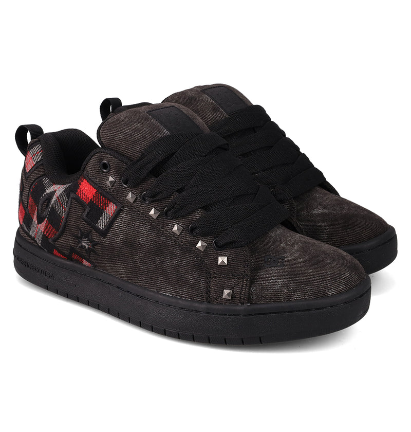 The Men's Court Graffik SE Shoes by DC Shoes are black skate sneakers with a puffy build, thick black laces, red and gray plaid accents, metal side studs, and black rubber soles.
