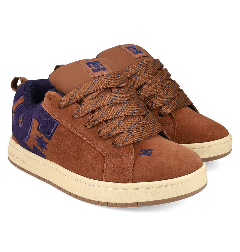 The Men's Court Graffik SE Shoes by DC Shoes feature a brown suede low-top design with puffy silhouette, padded collars, thick brown laces, cream soles, and purple DC logos on the sides and tongue for style and comfort.