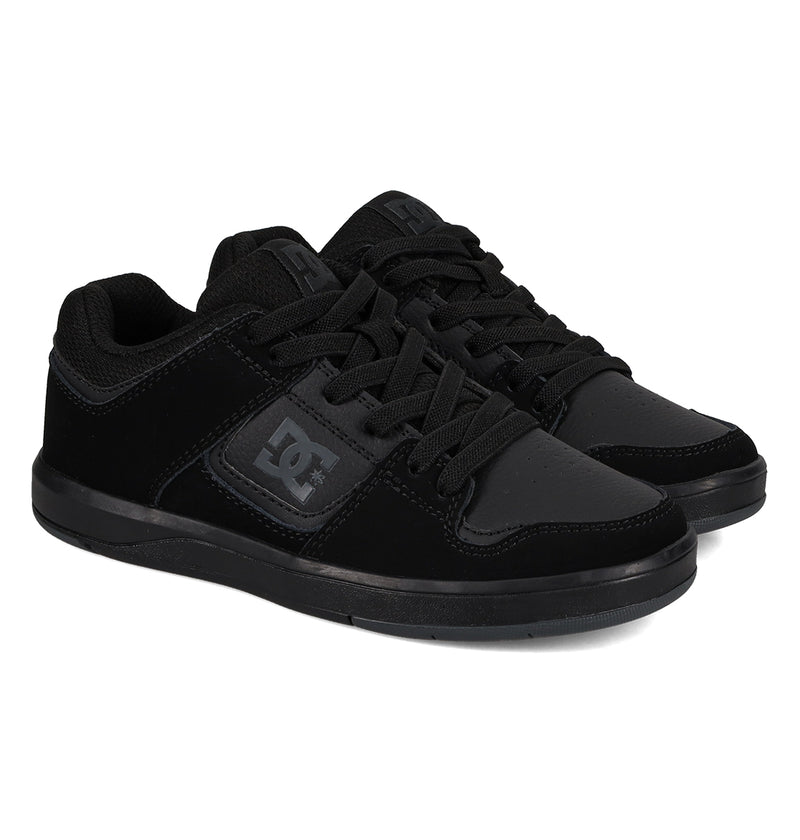 The Kids' DC Shoes Cure Elastic Shoes by DC Shoes are black skate shoes with black laces, black soles, and the DC logo on the side, photographed on a white background.