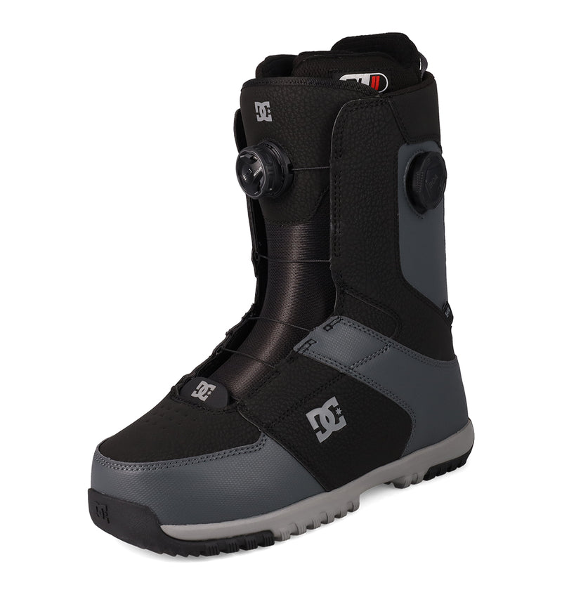 A single Men's Control Snowboard Boot by DC Shoes in black and gray, featuring a textured surface, a round adjustment dial with the Dual Zone BOA Fit System for precise control, and a thick sole, positioned on a white background.