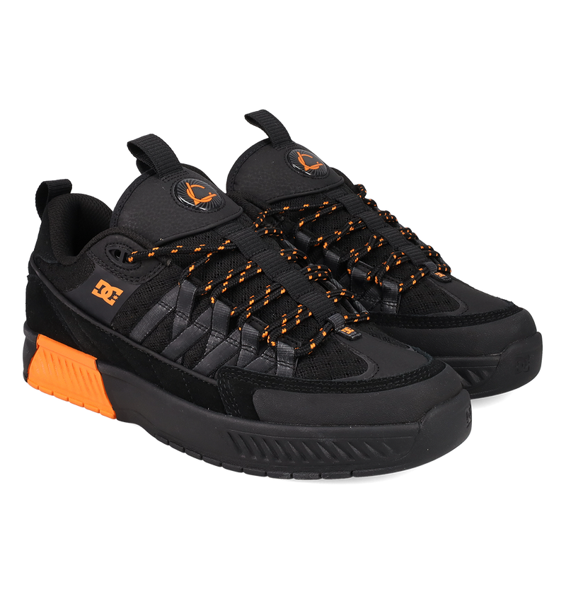 Black sneakers with orange accents on a white background