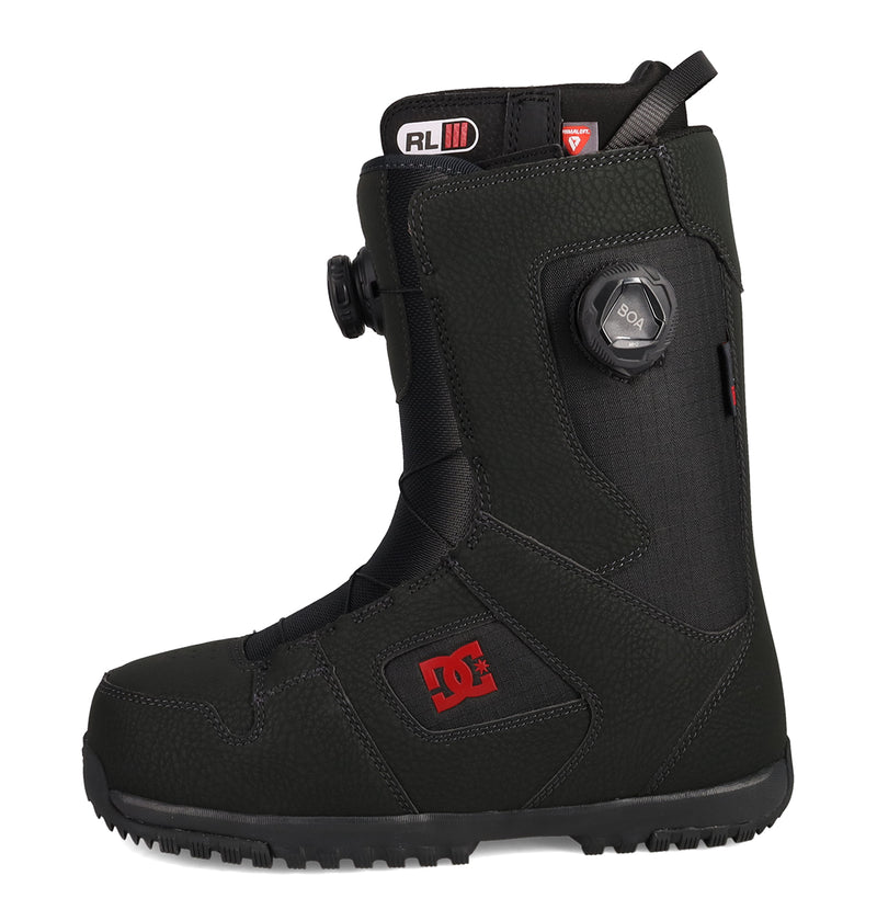 A pair of Men's Phase BOA® Pro Snowboard Boots from DC Shoes in black, featuring a rugged sole, distinctive red DC logo, and a side-mounted BOA dial lacing system for adjustable tightening. Enhanced with PrimaLoft insulation, these boots deliver warmth and comfort in cold conditions.