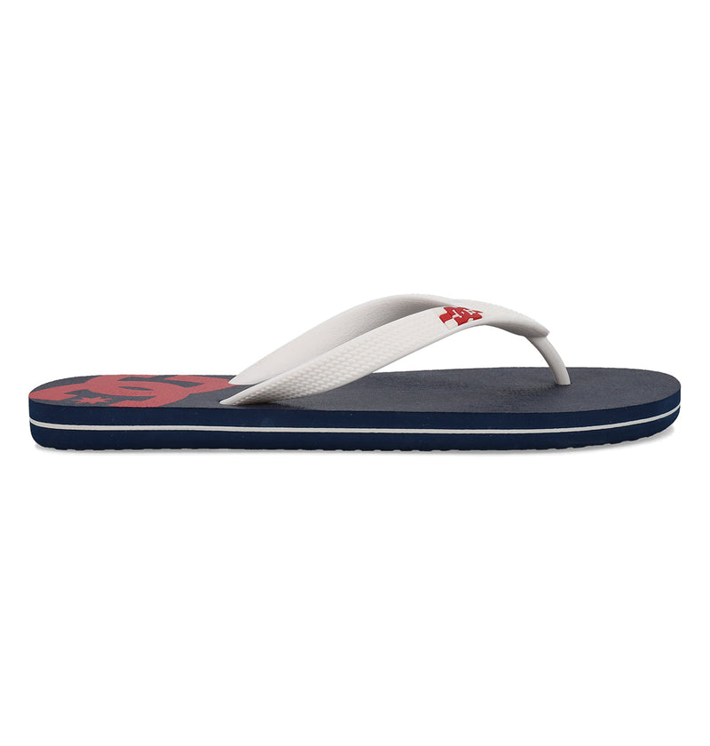 The Men's Spray Slides by DC Shoes feature a navy blue slip-on design with flat soles, white straps, and a red DC logo on the footbed—ideal for relaxing after a skate session.