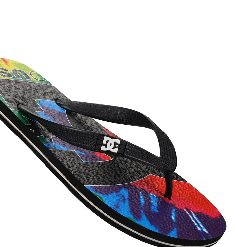 The Men's Spray Graffik Slides by DC Shoes feature a black strap with a white DC logo and a colorful tie-dye patterned sole—perfect for slipping on after skating.