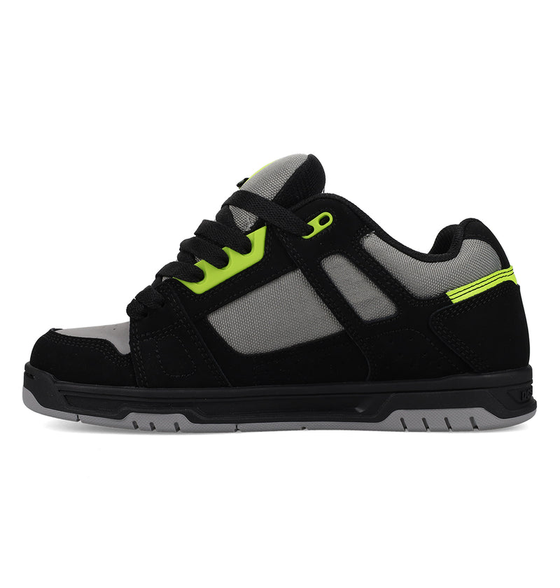 The Men's Stag Shoes by DC Shoes feature a black and gray design with neon green accents, black laces, mesh panel upper, durable cupsole, and rubber sole; displayed side profile on a white background.
