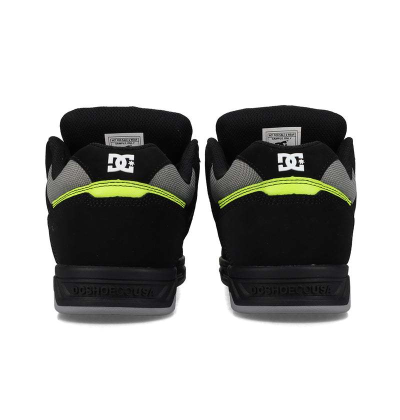 The Men's Stag Shoes by DC Shoes feature a black design with neon yellow accents, gray mesh details, and the white DC logo on the heels. Dynamic upper construction ensures both style and support for a standout look.