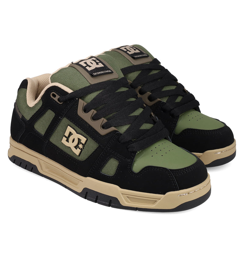 Men's Stag Shoes by DC Shoes in black, olive green, and beige feature black laces, beige soles, cupsole construction, and the DC logo in beige on the side and tongue.