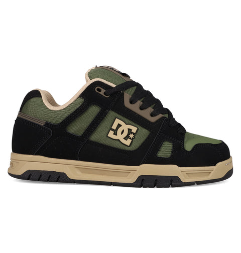 The DC Shoes Men's Stag skate shoe in black and olive green features beige accents, a side DC logo, durable cupsole, thick rubber sole, and black laces—built for long-lasting wear and true skate style.