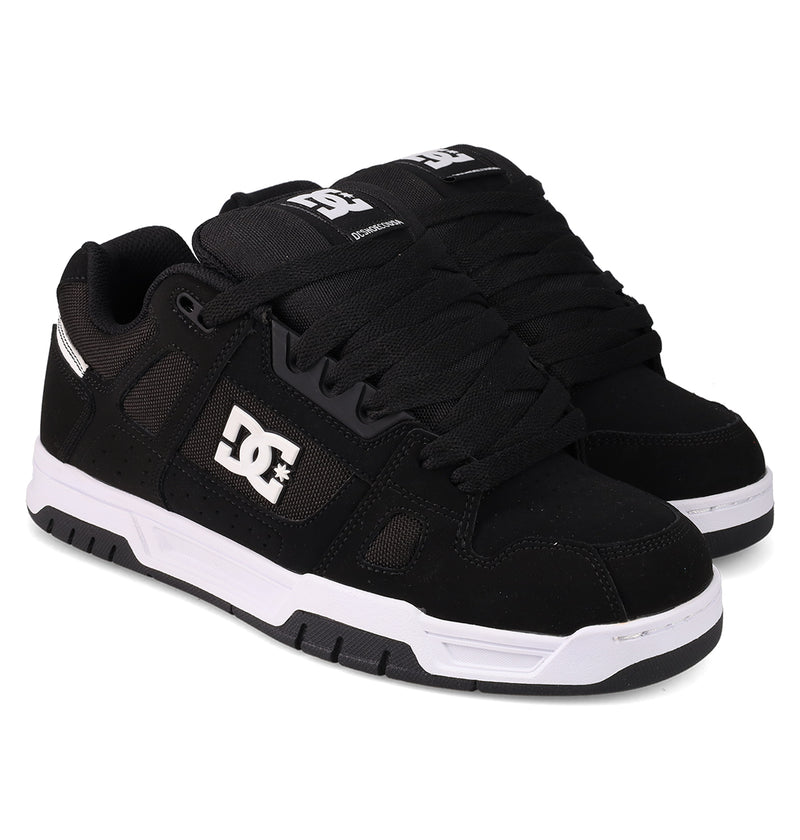 Men's Stag Shoes by DC Shoes in black with white soles and a white DC logo on the side, featuring durable cupsole construction, shown against a white background.