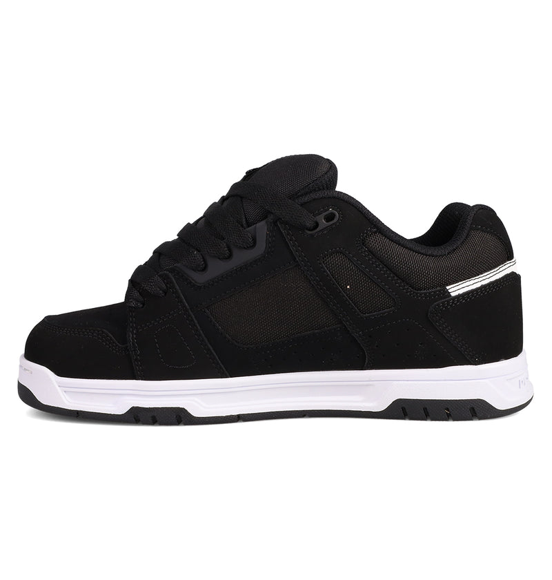 The DC Shoes Men's Stag Shoes are black athletic sneakers with mesh and suede panels, black laces, a thick white cupsole, padded collar, and subtle stitching details inspired by skate culture.