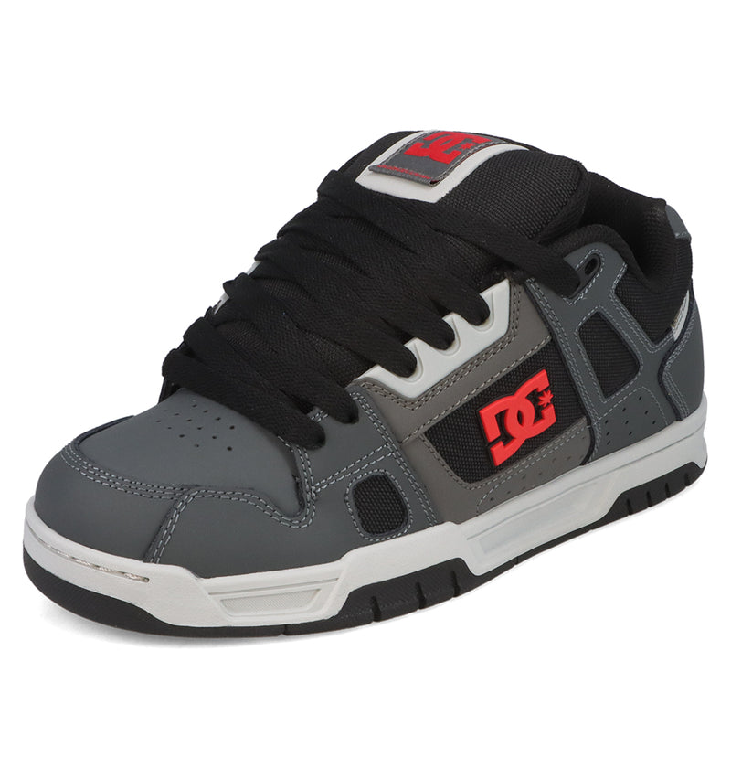 Introducing the Men’s Stag Shoes from DC Shoes: Featuring a stylish gray and black design with black laces, signature red DC logo on the side, crisp white sole, bold black accents, and a durable cupsole construction inspired by the iconic Stag silhouette—ideal for anyone passionate about skate culture.