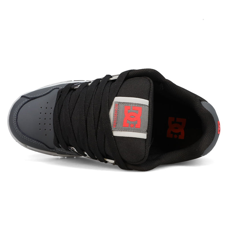 Top view of the Men’s Stag Shoes by DC Shoes in black and gray, showcasing thick black laces, a red DC logo on the tongue, and durable cupsole construction for added support—ideal for embracing authentic skate culture.