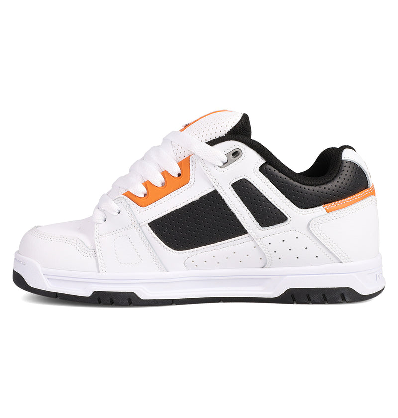 The Men's Stag Shoes by DC Shoes are white athletic sneakers with black and orange accents, black perforated side panels, white laces, a durable cupsole, and a thick treaded sole—delivering essential skate culture style.