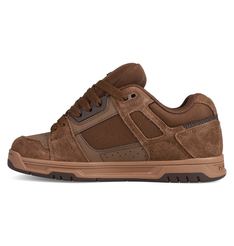 The DC Shoes Men's Stag features brown suede and mesh panels, thick laces, a sturdy rubber sole with cupsole construction, and visible stitching details in a low-top skate-inspired design.