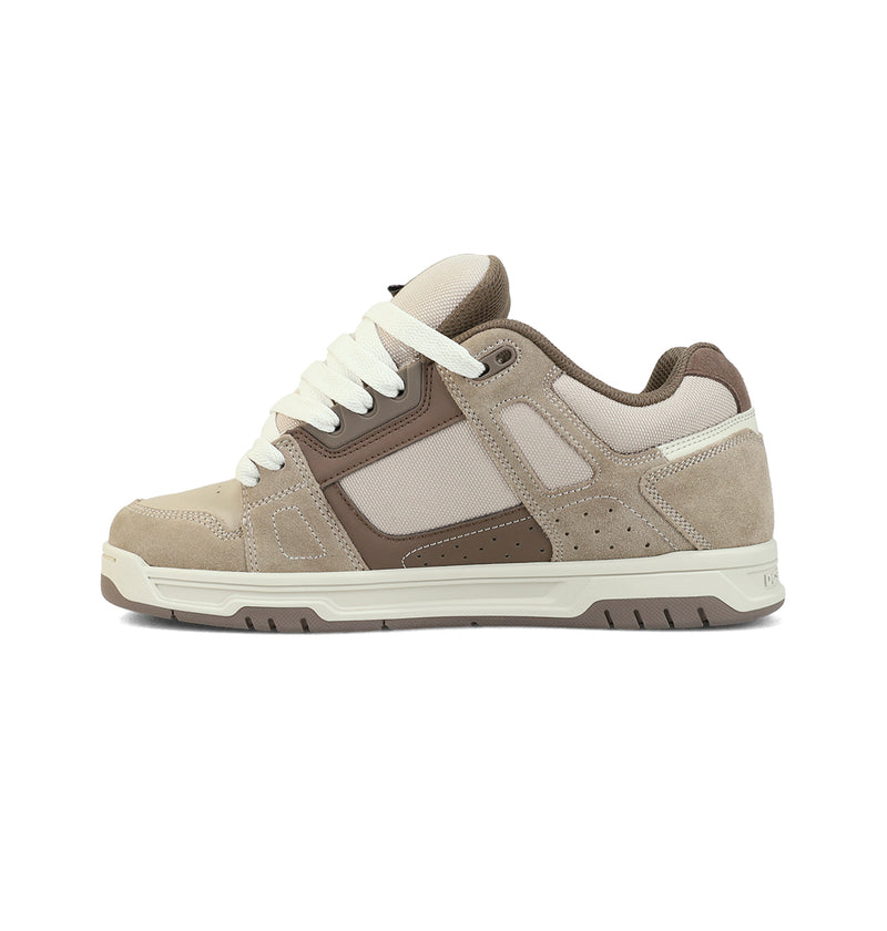 The DC Shoes Men's Stag Shoes, shown from the side on a white background, is a beige and brown skate-style sneaker with white laces, an oversized puff tongue, thick cupsole, and mesh and suede panels.