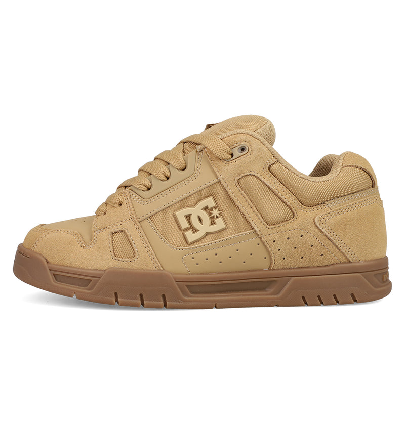 The Men's Stag Shoes by DC Shoes feature a tan color, thick gum sole, padded ankle, cupsole construction, mesh and suede panels, and a white side DC logo—shown in classic side profile.