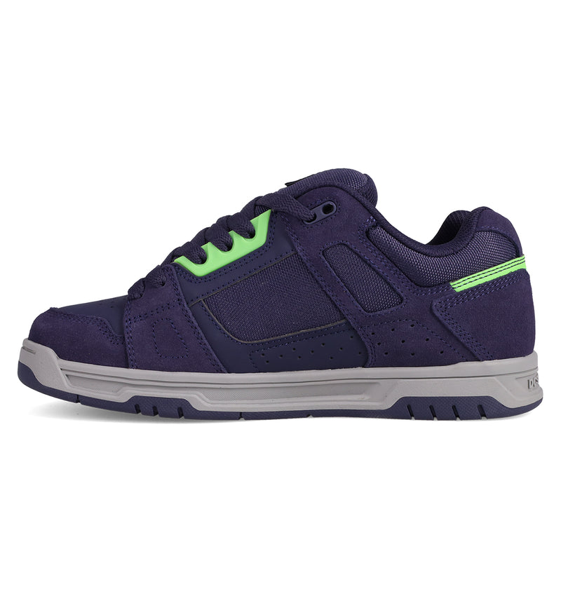 The DC Shoes Men's Stag Shoes feature a dark purple design with cupsole construction, light gray sole, neon green lace eyelets, and matching heel detail—classic skate-inspired style shown in a side profile.